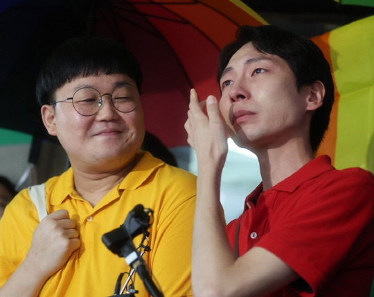 동성 연인 건강보험 피부양자 자격과 관련해 국민건강보험공단을 상대로 제기한 보험료 부과 처분 취소 소송에서 승소한 소성욱씨와 김용민씨(오른쪽)가 재판이 열린 서울 서초구 대법원 앞에서 소감을 밝히며 눈물을 훔치고 있다.<연합뉴스>